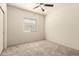 This bedroom features neutral carpet, a ceiling fan, window and light-colored walls at 24627 W Ripple Rd, Buckeye, AZ 85326