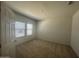 This bedroom features neutral carpet, a window providing natural light, and freshly painted walls, creating a blank canvas at 24627 W Ripple Rd, Buckeye, AZ 85326