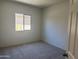 This bedroom features neutral carpet, a window providing natural light, and freshly painted walls, creating a blank canvas at 24627 W Ripple Rd, Buckeye, AZ 85326