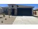 Home exterior with a large garage and desert landscaping at 24627 W Ripple Rd, Buckeye, AZ 85326