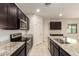 Modern kitchen with dark cabinetry, granite countertops, and stainless steel appliances at 24627 W Ripple Rd, Buckeye, AZ 85326