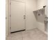 The laundry room features a utility sink, door to the outside and tiled floors at 24627 W Ripple Rd, Buckeye, AZ 85326
