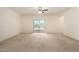 Expansive living room featuring plush carpeting and sliding glass doors to the backyard at 24627 W Ripple Rd, Buckeye, AZ 85326
