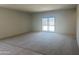 Spacious living room with neutral carpet, and a sliding door to the backyard at 24627 W Ripple Rd, Buckeye, AZ 85326