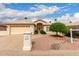Inviting beige home featuring a two-car garage, well-maintained landscaping, and a charming tile roof at 24907 S Lakestar Dr, Sun Lakes, AZ 85248