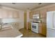 Bright kitchen featuring tile floors, white appliances, lots of cabinet space, and neutral countertops at 24907 S Lakestar Dr, Sun Lakes, AZ 85248