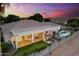 Backyard at sunset features a pool, spa, and covered patio with outdoor seating and ambient lighting at 2625 N 24Th St # 22, Mesa, AZ 85213
