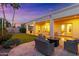 Outdoor patio with pavers, string lights, wicker furniture, and a backyard lawn at sunset at 2625 N 24Th St # 22, Mesa, AZ 85213