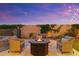 Backyard patio with a fire pit, conversation set, and lush landscaping at twilight at 2625 N 24Th St # 22, Mesa, AZ 85213