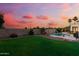 Beautiful backyard with a pool, lush greenery, and a stone accent wall at sunset at 2625 N 24Th St # 22, Mesa, AZ 85213