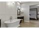 Elegant bathroom with a freestanding tub, chandelier, and wood-look tile floors, offering luxury and style at 2625 N 24Th St # 22, Mesa, AZ 85213