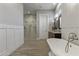Bright bathroom featuring a soaking tub, walk-in shower, dual vanity, and wood-look tile flooring at 2625 N 24Th St # 22, Mesa, AZ 85213