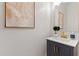 Stylish powder room with a sleek vanity, gold fixtures, and modern abstract art at 2625 N 24Th St # 22, Mesa, AZ 85213