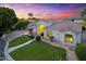 Beautiful single-story home features lush landscaping, a well-manicured lawn, and a welcoming entrance at sunset at 2625 N 24Th St # 22, Mesa, AZ 85213