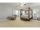 Serene main bedroom with a four-poster bed and a sliding barn door to the bathroom at 2625 N 24Th St # 22, Mesa, AZ 85213
