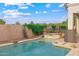 Freeform backyard pool with stone accents, lush landscaping and mature trees at 2625 N 24Th St # 22, Mesa, AZ 85213