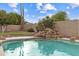 Inviting swimming pool with rock waterfall feature, set against a backdrop of lush landscaping and privacy fencing at 2625 N 24Th St # 22, Mesa, AZ 85213