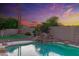 Backyard swimming pool with rock waterfall feature, landscaping and privacy fence at sunset at 2625 N 24Th St # 22, Mesa, AZ 85213