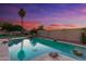 A large swimming pool at sunset with waterfalls and tropical landscaping provides a backyard oasis at 2625 N 24Th St # 22, Mesa, AZ 85213