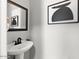 Modern powder room with a pedestal sink, decorative mirror, and unique modern artwork at 2648 E Teakwood Pl, Chandler, AZ 85249