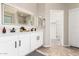 Bathroom featuring double sinks, white cabinets, and a large lighted mirror at 2648 E Teakwood Pl, Chandler, AZ 85249