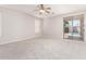 Bright bedroom featuring neutral carpet, ceiling fan, and sliding glass door leading to a backyard swimming pool at 2648 E Teakwood Pl, Chandler, AZ 85249