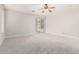 A large, carpeted bedroom with a ceiling fan and a sliding glass door overlooking a pool at 2648 E Teakwood Pl, Chandler, AZ 85249