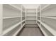Walk-in closet featuring neutral carpeting and multiple rows of shelving at 2648 E Teakwood Pl, Chandler, AZ 85249