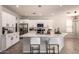 Modern kitchen boasts sleek white cabinets, stainless steel appliances, and a spacious island with seating at 2648 E Teakwood Pl, Chandler, AZ 85249