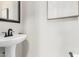 Stylish powder room with pedestal sink, framed mirror, and neutral decor, adding a touch of elegance at 2648 E Teakwood Pl, Chandler, AZ 85249