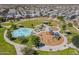 Aerial view of a community park featuring splash pad, playground, picnic areas, and green spaces at 30963 W Columbus Ave, Buckeye, AZ 85396
