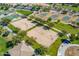 Aerial view showcasing community park with volleyball, tennis, and basketball courts, nestled among lush landscaping at 30963 W Columbus Ave, Buckeye, AZ 85396