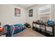 Comfortable bedroom with a bed, storage shelf with toys, and a window at 30963 W Columbus Ave, Buckeye, AZ 85396