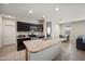 Kitchen with stainless steel appliances, dark cabinets, granite countertops, and large center island at 30963 W Columbus Ave, Buckeye, AZ 85396