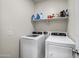 Functional laundry room with a modern washer and dryer, plus overhead shelving at 30963 W Columbus Ave, Buckeye, AZ 85396