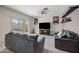 Open living room with a sliding glass door to the backyard and a large TV with console at 30963 W Columbus Ave, Buckeye, AZ 85396