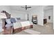 Bright main bedroom showcasing a dark wood bed frame, a ceiling fan, and ensuite bathroom at 36085 W Prado St, Maricopa, AZ 85138