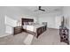 Bright main bedroom featuring a dark wood bed frame, neutral walls, and ceiling fan at 36085 W Prado St, Maricopa, AZ 85138