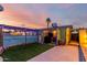 Charming backyard featuring an outdoor kitchen, artificial grass, and cozy, covered patio at 3643 E Friess Dr, Phoenix, AZ 85032