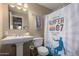 Cozy bathroom features a surfboard-themed shower curtain and a pedestal sink at 3643 E Friess Dr, Phoenix, AZ 85032