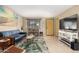 Bright living room featuring tile floors, tropical decor, and a large flat screen TV at 3643 E Friess Dr, Phoenix, AZ 85032