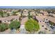 Aerial view of a suburban home in a quiet neighborhood with a tile roof and green trees at 3823 S 101St Dr, Tolleson, AZ 85353