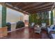 Inviting covered patio with comfortable seating, a grill, and lush green privacy screens at 3823 S 101St Dr, Tolleson, AZ 85353