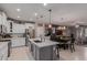 Open-concept kitchen with white cabinets, a center island, and dining area with modern lighting at 3823 S 101St Dr, Tolleson, AZ 85353
