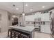 Bright kitchen featuring a center island with barstool seating, stainless steel appliances and white cabinets at 3823 S 101St Dr, Tolleson, AZ 85353