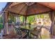 Charming outdoor dining area with gazebo, string lights, decorative fireplace, and green landscaping at 3823 S 101St Dr, Tolleson, AZ 85353