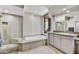 Bright bathroom with soaking tub, glass enclosed shower and stone countertops at 39032 N 101St Way, Scottsdale, AZ 85262