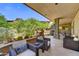 Charming covered patio featuring comfortable seating, stone pillars, and lush desert landscaping at 39032 N 101St Way, Scottsdale, AZ 85262