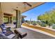 Covered patio boasts stone pillars, tiled flooring, comfortable seating, and scenic desert views at 39032 N 101St Way, Scottsdale, AZ 85262