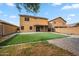 Large backyard with artificial turf, pavers, block fencing, and a covered patio at 4587 E Silverbell Rd, San Tan Valley, AZ 85143